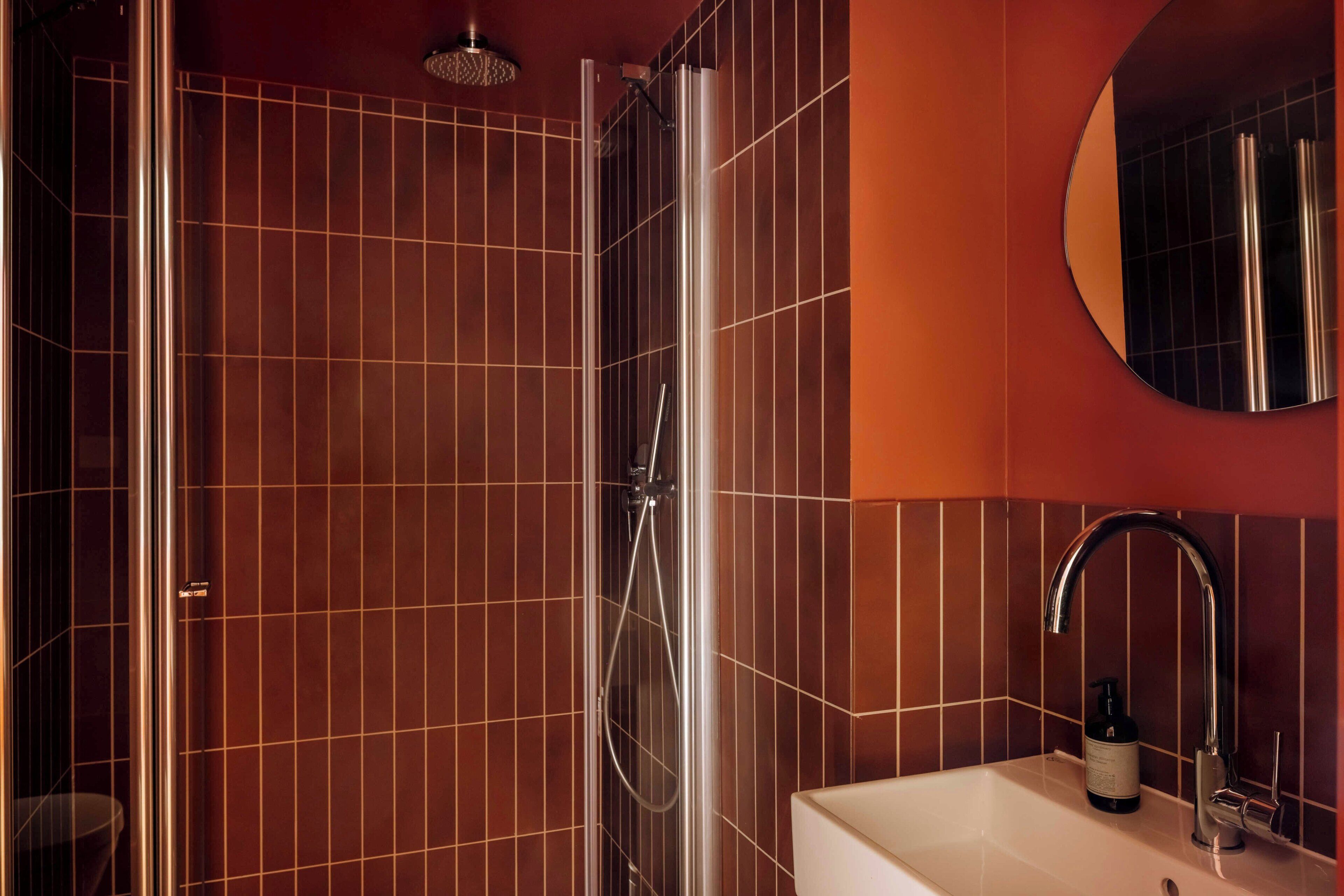 A bathroom with a shower, a sink, and a mirror.