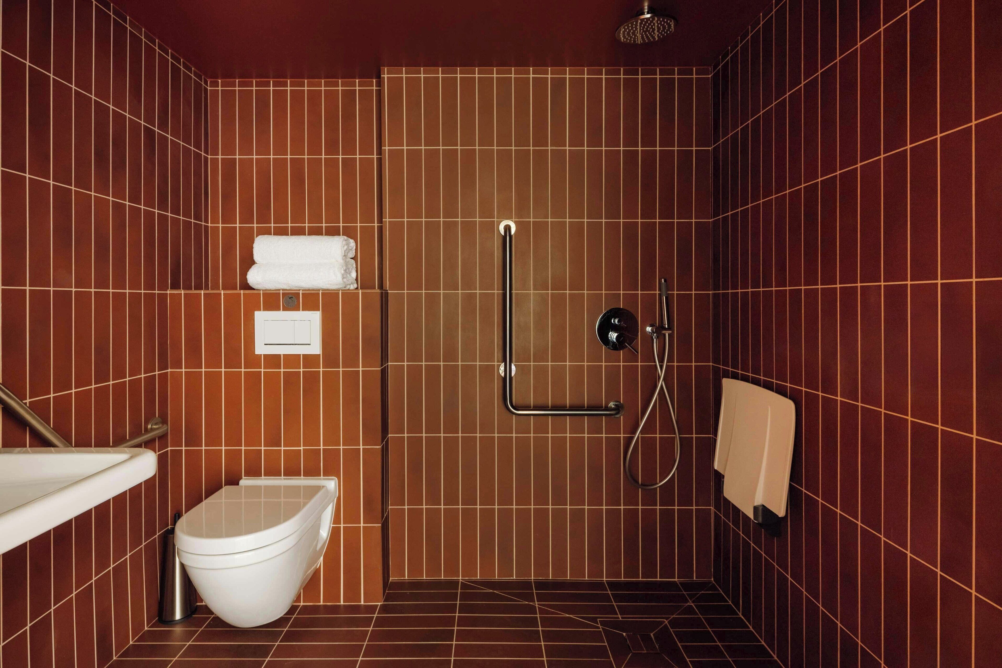 A bathroom with a toilet, sink, and shower.