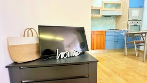 Une cuisine moderne avec des meubles en bois, un four encastré et un coin repas comprenant une table et des chaises.