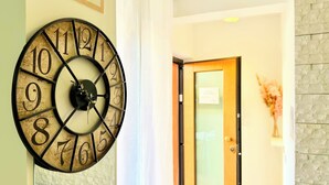 Une horloge murale avec des chiffres romains, placée dans un couloir.