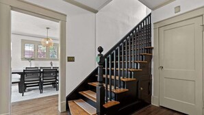 A staircase with wooden steps and black railings, leading to a white door.