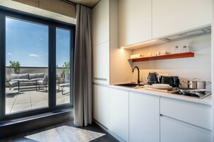 Una cocina moderna con un ventanal grande, un comedor con sofá y vista al cielo.