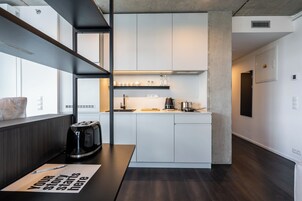 Una cocina moderna con armarios blancos, una cafetera y un tostador sobre la encimera.