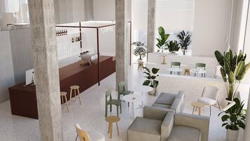 A modern interior with a coffee bar, seating areas, and potted plants.
