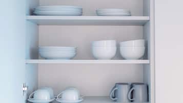 A white cabinet with shelves containing white bowls, plates, and grey mugs.