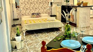 A neatly arranged bedroom with a bed, bedside tables, a nightstand, a mirror, and a small potted plant. - Spacious loft in the heart of a quiet and lively beach town.  (Arona)