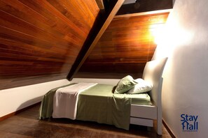 A single bed in a room with sloped wooden ceilings and a white wall. - Bangalô 4qts BeiraMar em Muro Alto-SH034 (Ipojuca)