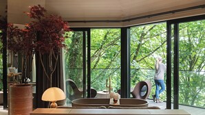 Un intérieur moderne avec de grandes fenêtres, un coin salon et une plante en pot.