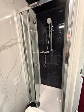 Chambre familiale | Salle de bain | Douche, articles de toilette (gratuits), serviettes fournies