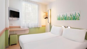 A hotel room with a bed, a desk, a television, and a painting on the wall. - B&B HOTEL Zaragoza Plaza Mozart  (Zaragoza)
