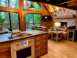 Une cuisine spacieuse dotée d’un grand îlot central, de meubles en bois et d’un four encastré.