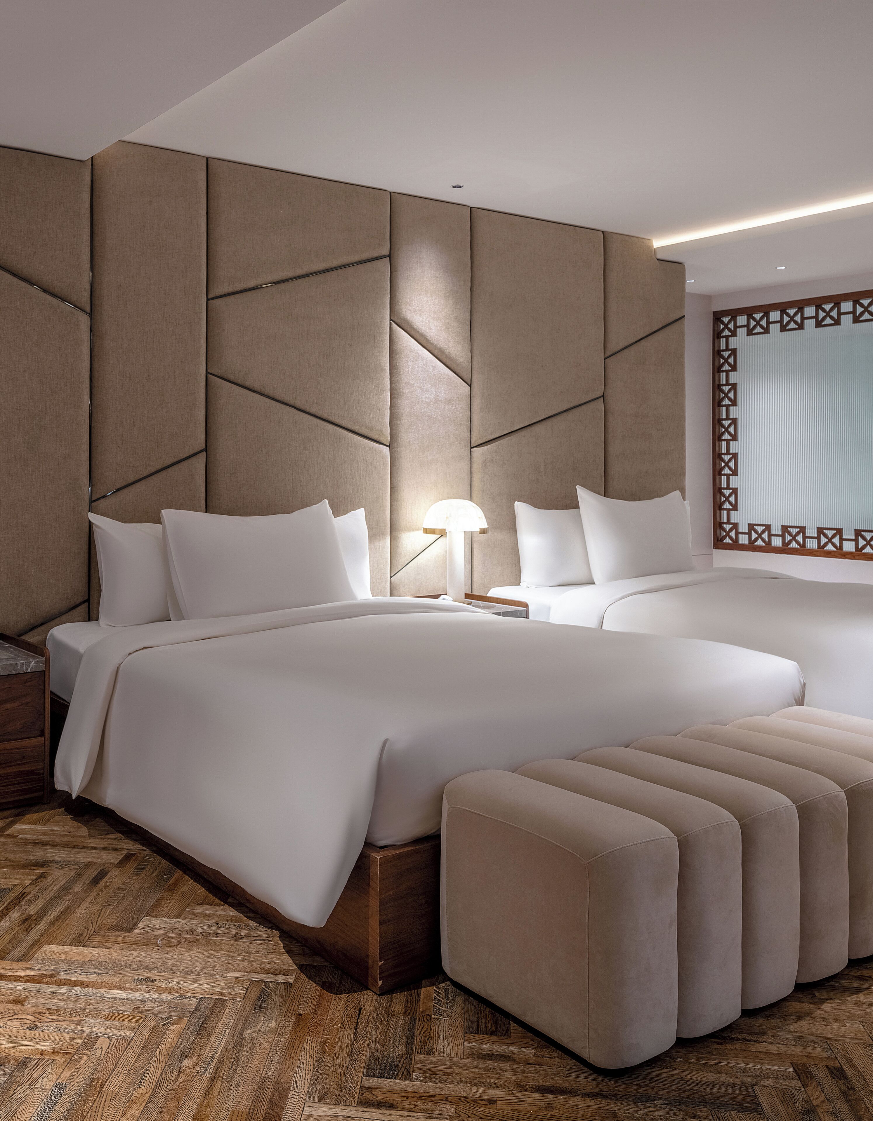 A modern bedroom with a large bed, a nightstand, and a seating area.