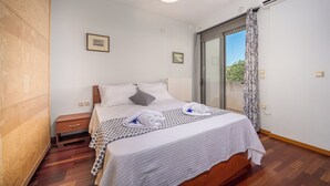 Una camera da letto con un letto, comodini, abat-jour e una finestra con tende.