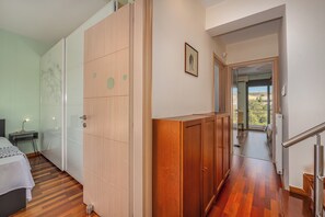 A bedroom with a bed, a nightstand, a wardrobe, and a bathroom visible through a glass door. - Villa Galano: Explore the Athenian Riviera (Vari)