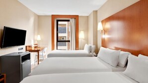 Une chambre d’hôtel avec deux lits, une télévision, un bureau et une fenêtre avec des rideaux.