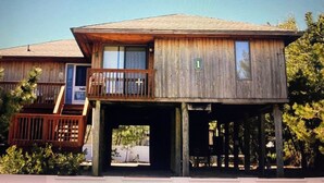 Una cabana de fusta amb un balcó, una terrassa i un rètol amb el número 1.
