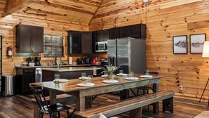 L’intérieur d’un chalet en bois comprend une cuisine, une table à manger et des bancs.
