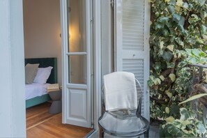 Une pièce comprenant un lit, une chaise et une porte donnant sur une autre pièce.