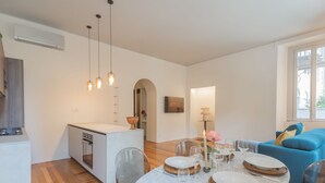 A modern living space with a dining area, kitchen, and seating area. - Como Liberty Suites - Garbo (Como)