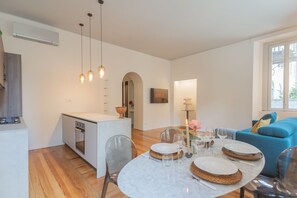 A modern living space with a dining area, kitchen, and seating area. - Como Liberty Suites - Garbo (Como)