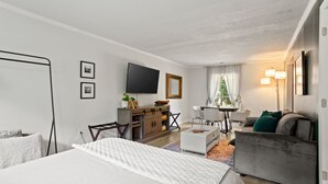 A modern hotel room with a large bed, a sofa, a desk, and a TV. - Secluded Spiritual Oasis in Travelers Rest (Travelers Rest)
