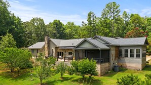 A two-story house with a covered patio, surrounded by a well-maintained lawn and trees. - Secluded Spiritual Oasis in Travelers Rest (Travelers Rest)