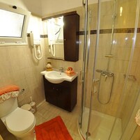 A bathroom with a toilet, sink, and shower.