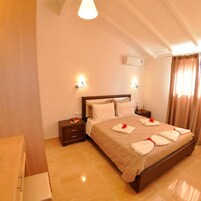 Habitación de hotel con una cama grande, dos mesitas de noche, un escritorio y una silla.