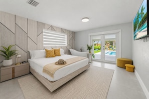 Quarto moderno com uma cama grande, vista para o exterior e piscina.