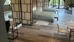 A spacious loft bedroom with a large bed, a desk, and a dining area. - Gite BELLA VITA (2 to 6 people). 2-hour access to wellness area possible at extra cost, subject to availability (GUSSIGNIES)