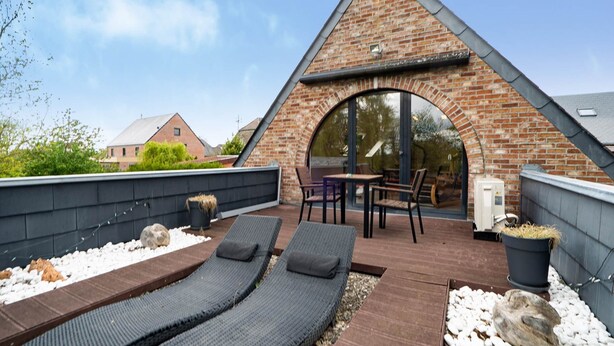 A rooftop patio with two lounge chairs, a table, and a brick archway. - Gite BELLA VITA (2 to 6 people). 2-hour access to wellness area possible at extra cost, subject to availability (GUSSIGNIES)