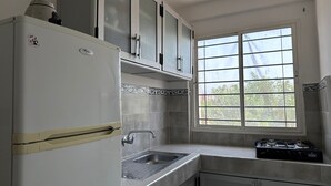 A kitchen with a refrigerator, a sink, cabinets, and a window. - Quiet apartment in downtown Agadir (Agadir)