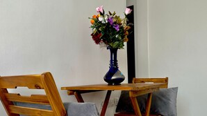 A wooden dining table with a blue vase of flowers. - Quiet apartment in downtown Agadir (Agadir)