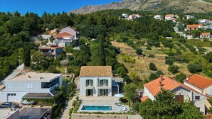 A residential area with houses, a swimming pool, and a mountainous backdrop. - Hedera Estate, Villa Hedera Xviii (Zupa dubrovacka)