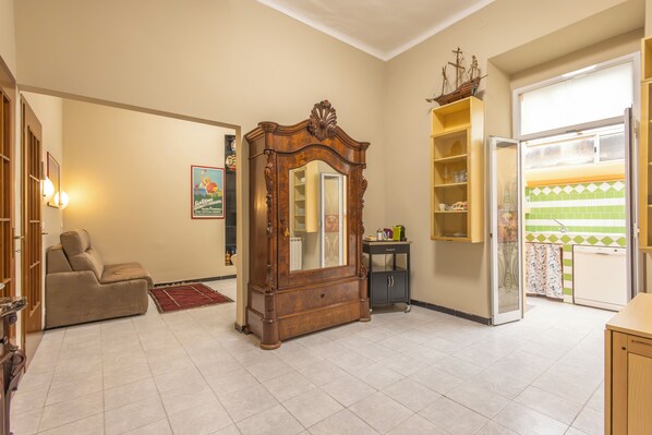 A living room with a wooden cabinet, a sofa, and a tiled floor.
