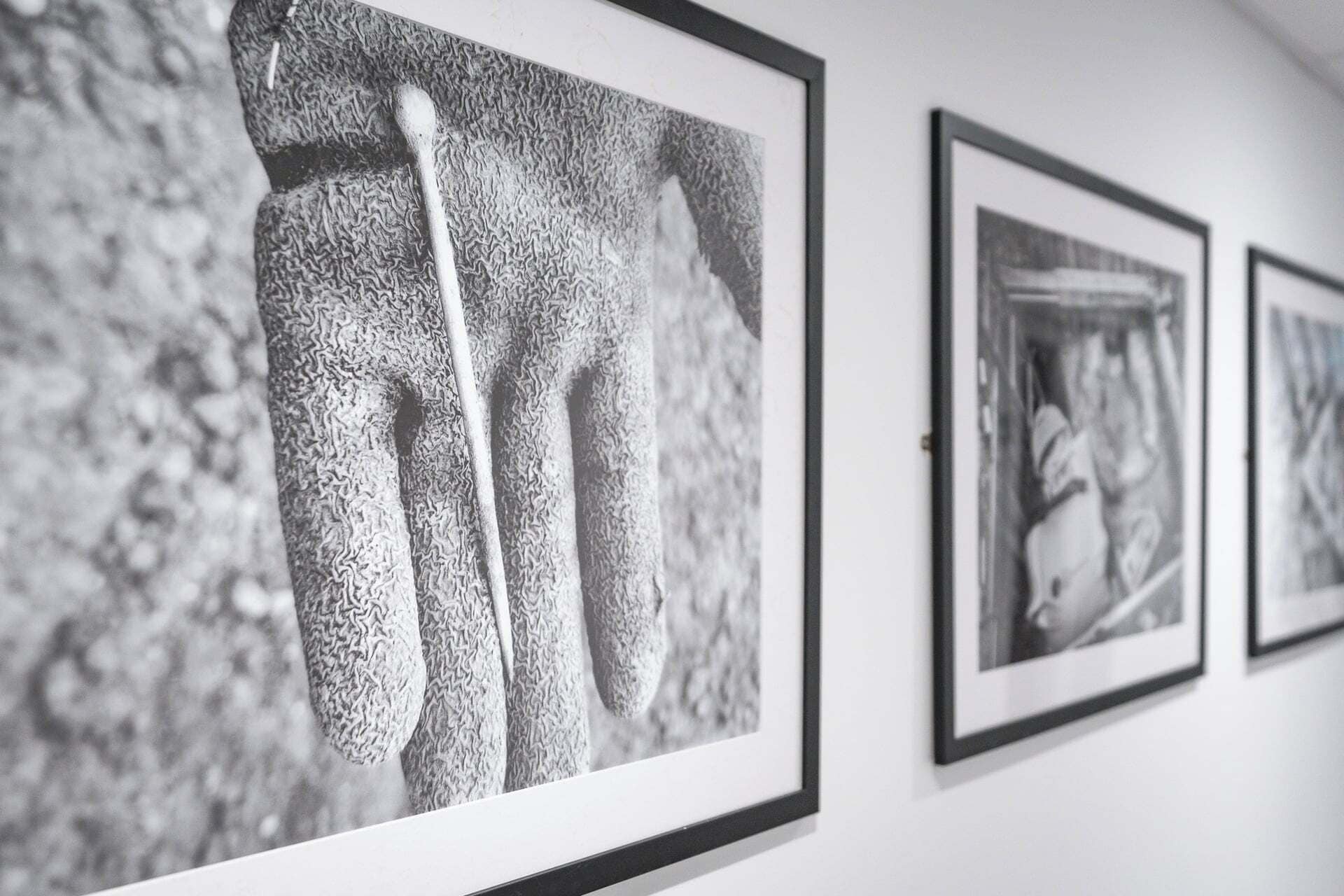 A wall with framed black and white photographs.