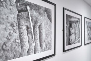 Una pared con fotografías en blanco y negro enmarcadas.