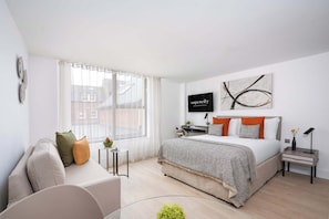 A modern bedroom with a bed, a sofa, a TV, and a window. - Micklegate by Supercity Aparthotels (York)