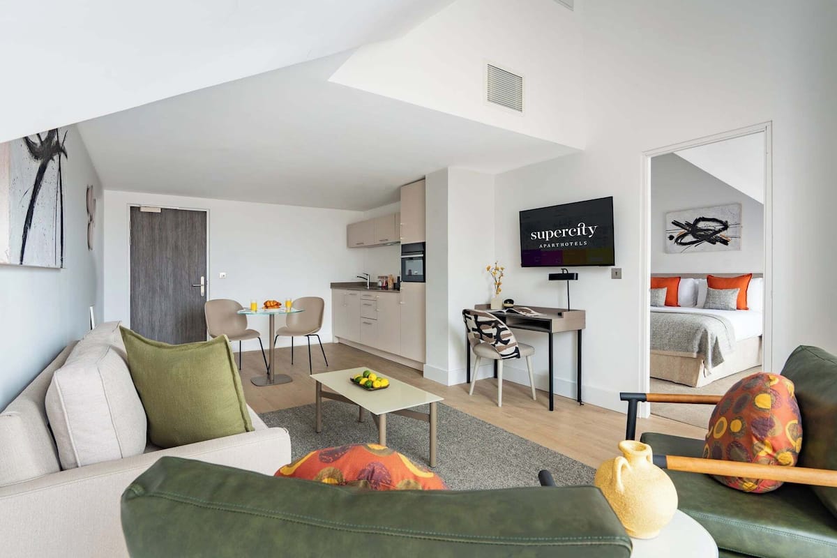 Un apartament modern amb saló, cuina i dormitori.