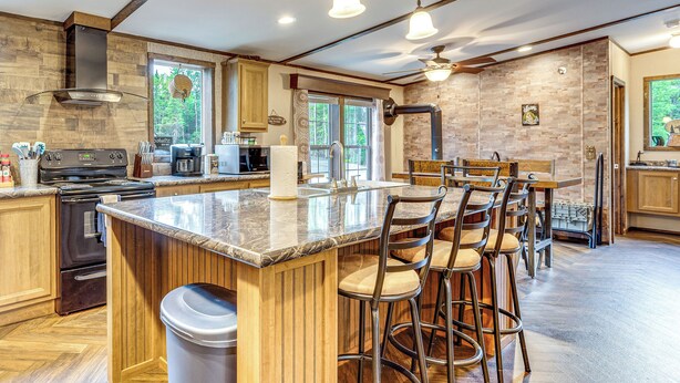 A modern kitchen with a central island, bar stools, and a view of the outdoors. - 4 Mi to Lake Francis: Peaceful Pittsburg Home (Pittsburg)