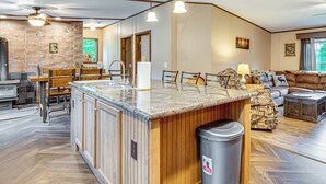 A spacious kitchen with a central island, wooden cabinetry, and a herringbone floor pattern. - 4 Mi to Lake Francis: Peaceful Pittsburg Home (Pittsburg)