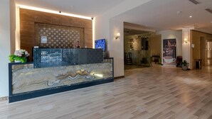 A hotel reception area with a marble reception desk, a patterned wall, and a modern interior design. - Al Salamh suites Family - أجنحة السلامة العائلية (Jeddah)