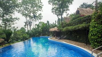 Una piscina al aire libre, tumbonas
