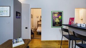 Un apartamento moderno con cocina, comedor y un pasillo que lleva al dormitorio.