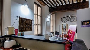 Una cocina con tostadora, hervidor y estufa a gas. Hay un extintor rojo en la encimera.