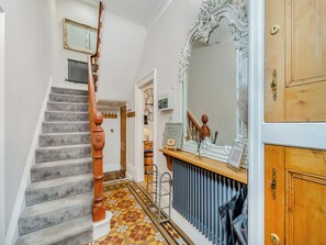 A staircase with a wooden handrail, a radiator, and a patterned floor. - 6 bedroom accommodation in York (York)