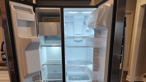 An open refrigerator with multiple shelves and a freezer compartment. - A luxurious getaway in beautiful Buford. (Buford)