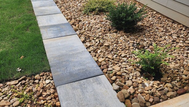 A concrete pathway leading to a house with a lawn and a rock garden. - A luxurious getaway in beautiful Buford. (Buford)