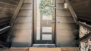 A wooden door with a wreath, a doormat, and a small light fixture above it. - Fully Remodeled Home Away From Home with all the amenities (Sugarloaf)