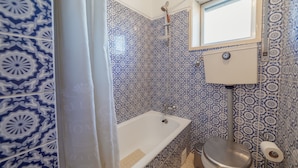 Une salle de bain avec une baignoire, des toilettes et une douche.